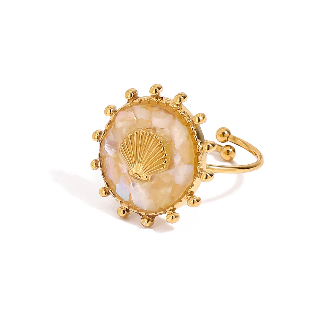 Gold ring with a shell design on a white background