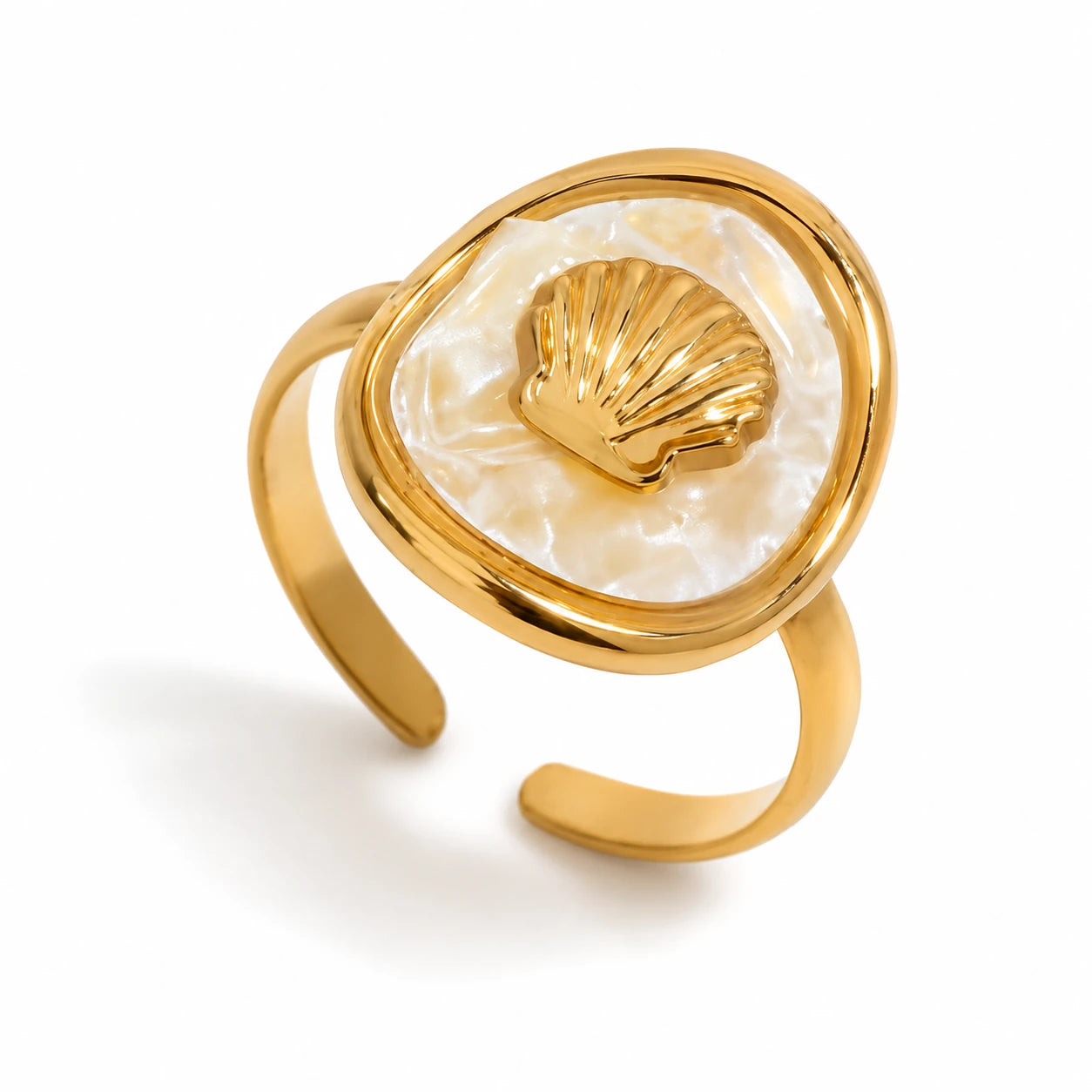 A gold-plated open ring band featuring a large, irregularly shaped cream-colored mother-of-pearl inlay with a small, raised gold scallop shell in the center, set against a clean white background.