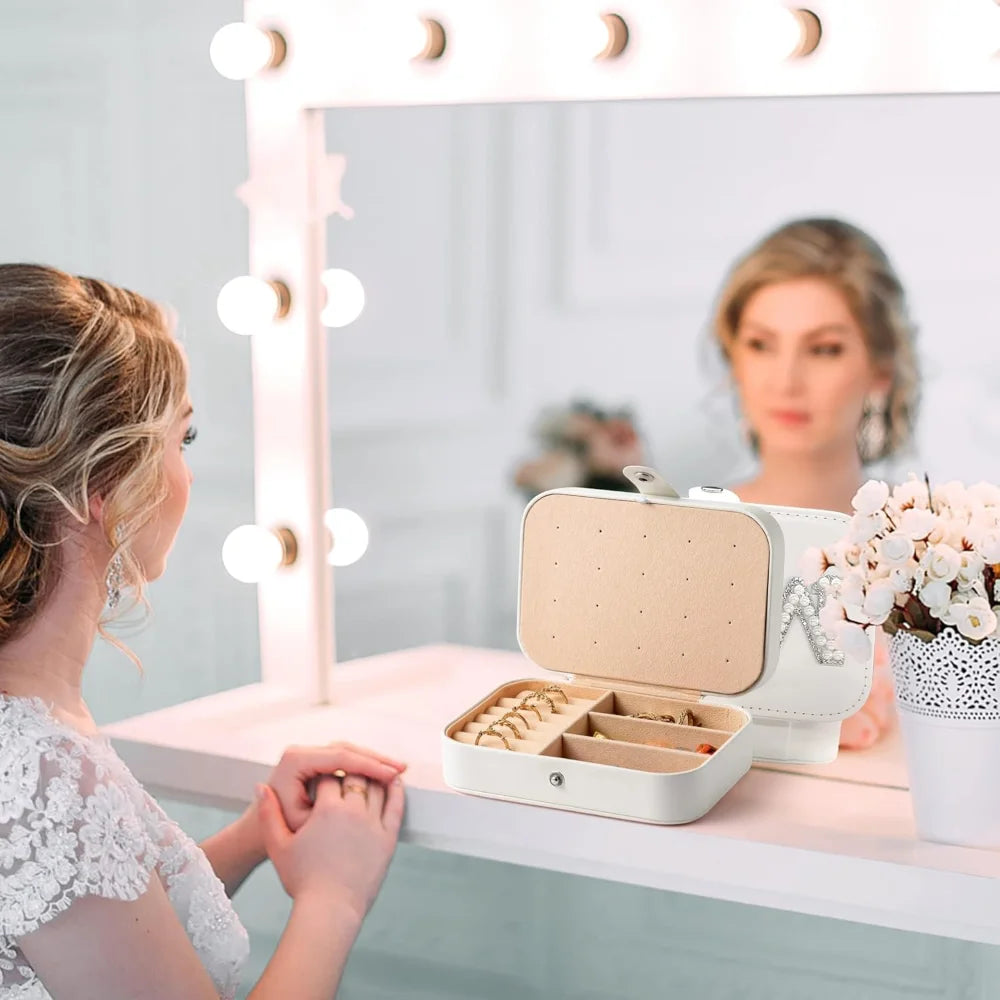 Woman looking at a jewelry box on a vanity mirror with lights.