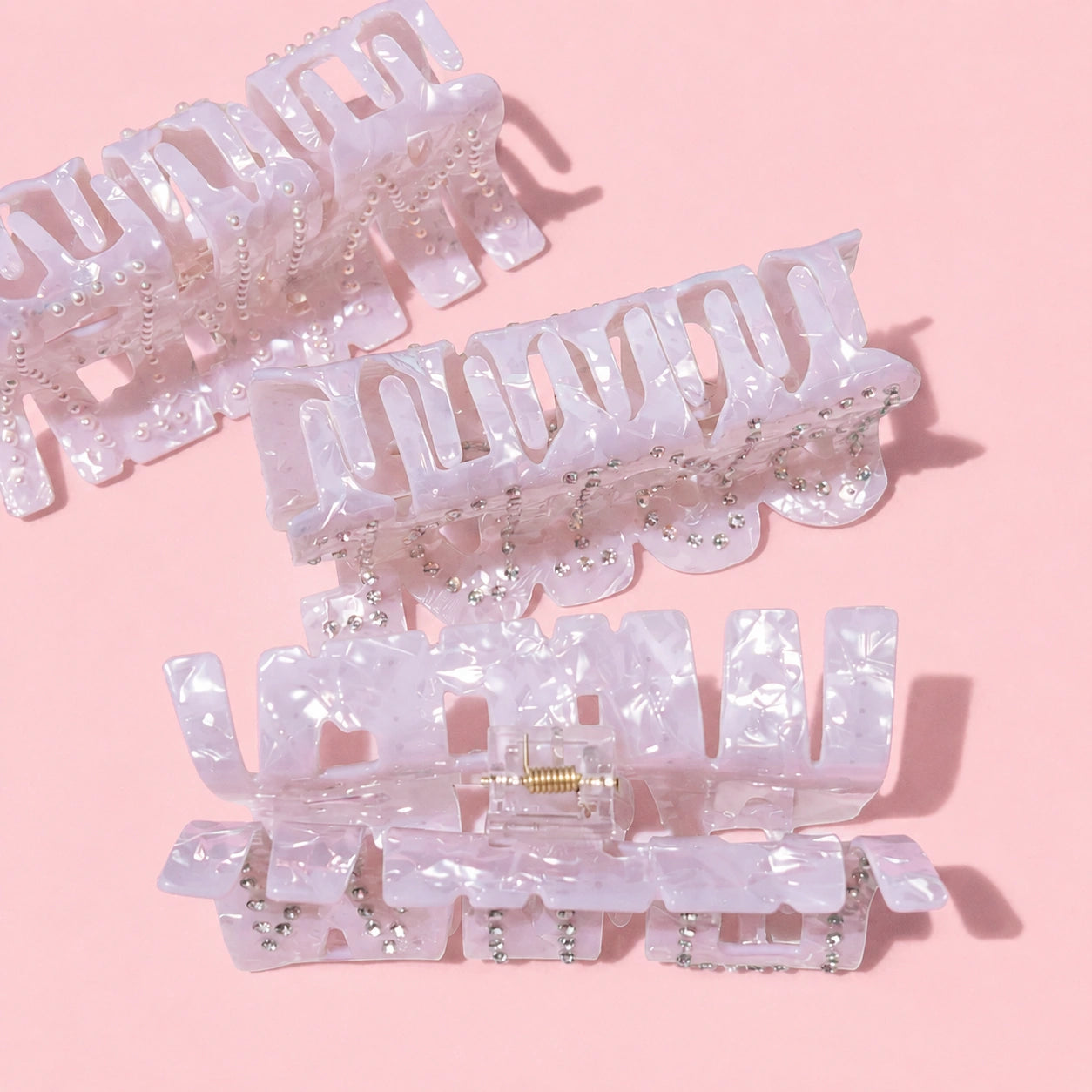 Set of white bridal hair clips on a pink background