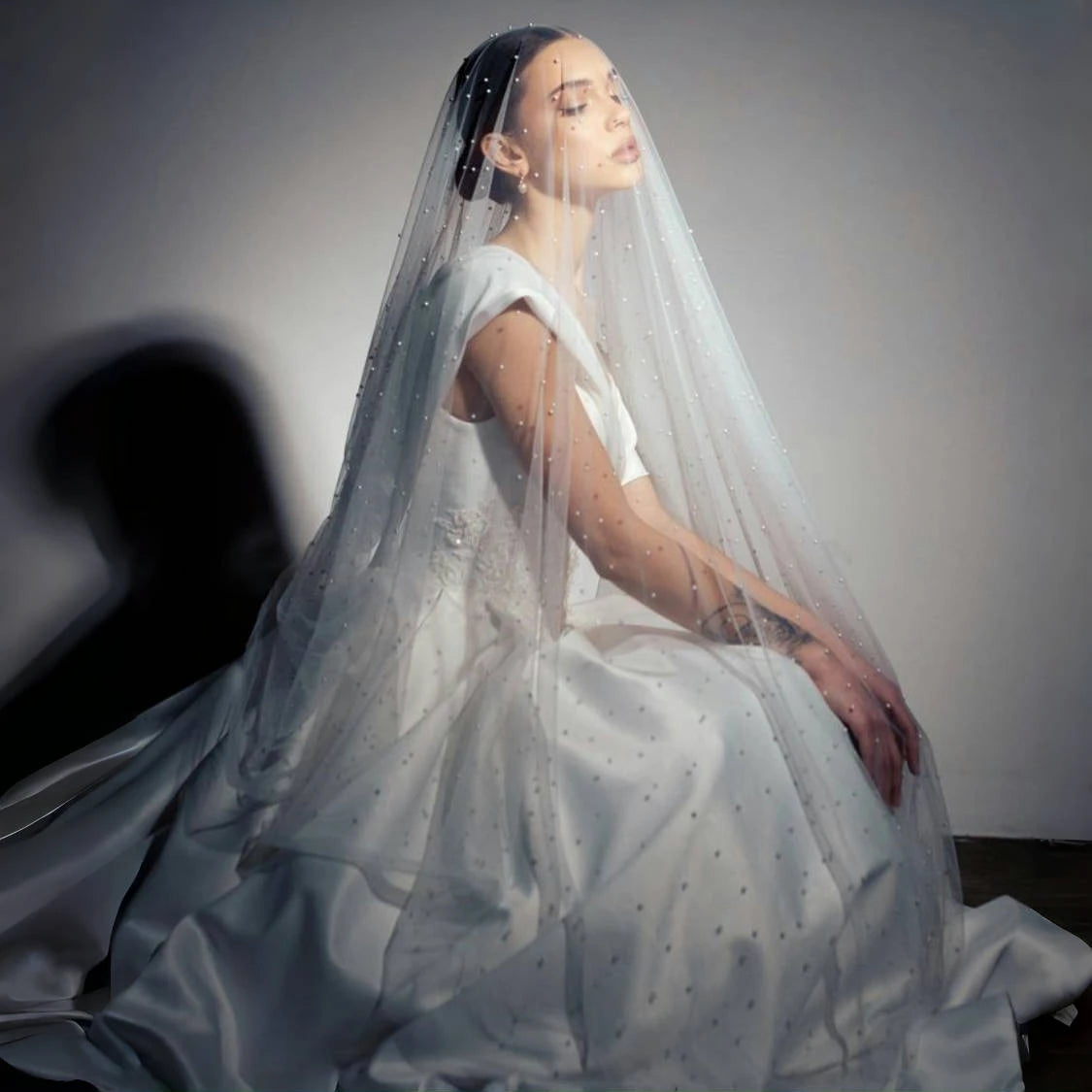 Side view of bride wearing a pearl-dotted bridal veil with soft layered tulle for a romantic bridal look.