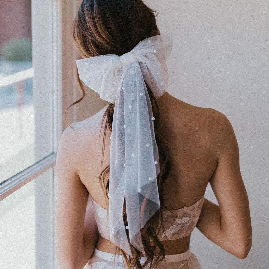 Bride wearing white sheer pearl hair bow for a hen party