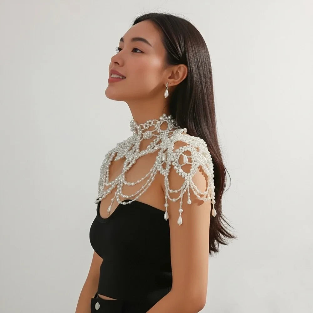 Woman wearing a decorative pearl shoulder piece against a plain background