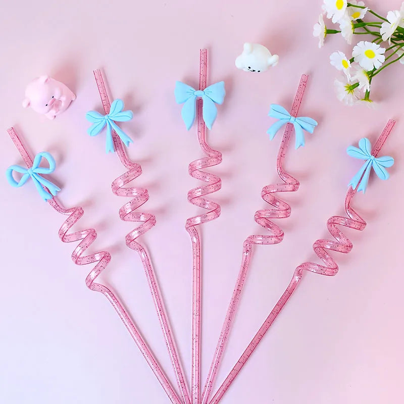 Pink spiral straws with blue bows on a pink background