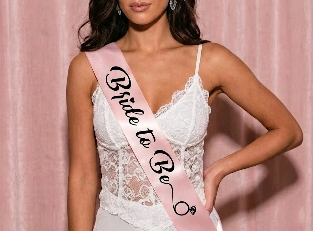 Woman wearing a 'Bride to Be' sash against a pink background