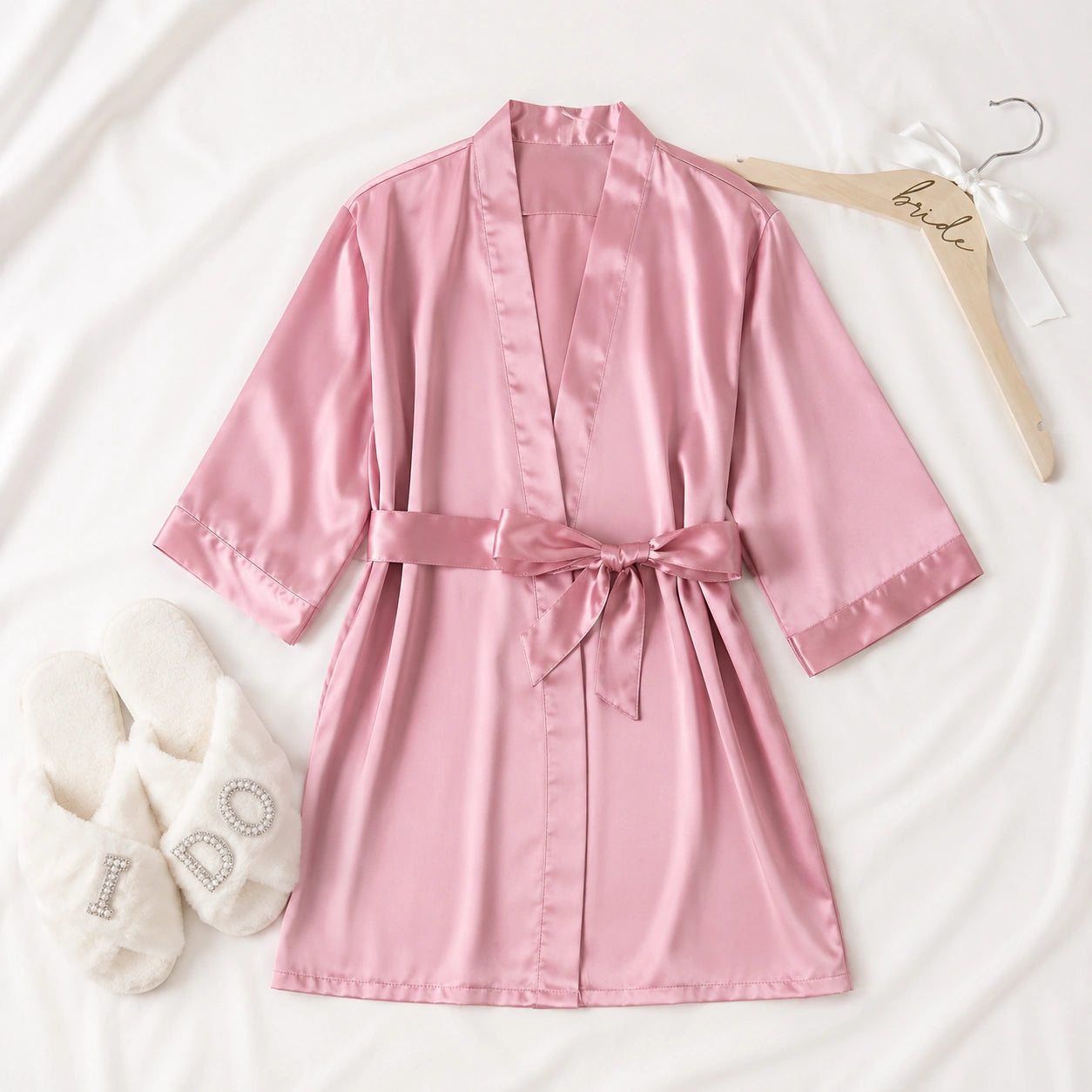 Pink satin robe with a matching hanger on a white background