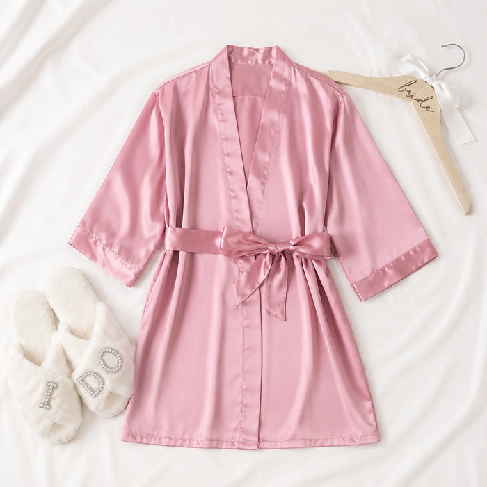 Pink satin robe with a matching hanger on a white background