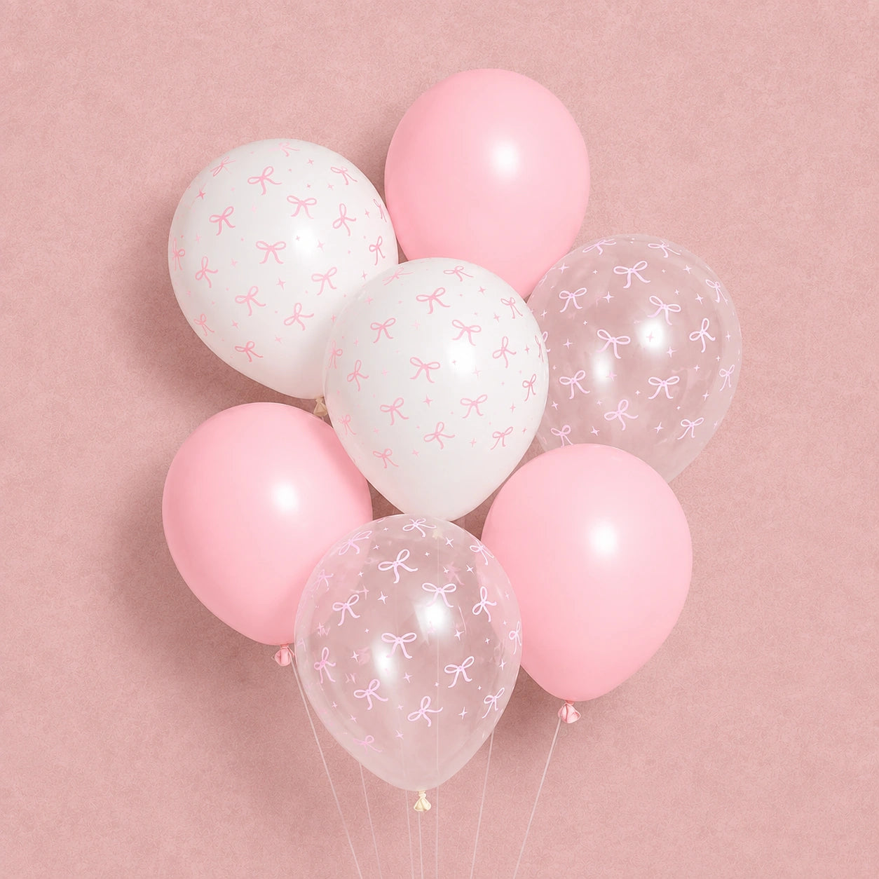 A cluster of pastel balloons on a soft pink background, including solid light pink balloons, white balloons with small pink bow prints, and clear balloons with pink bow patterns.