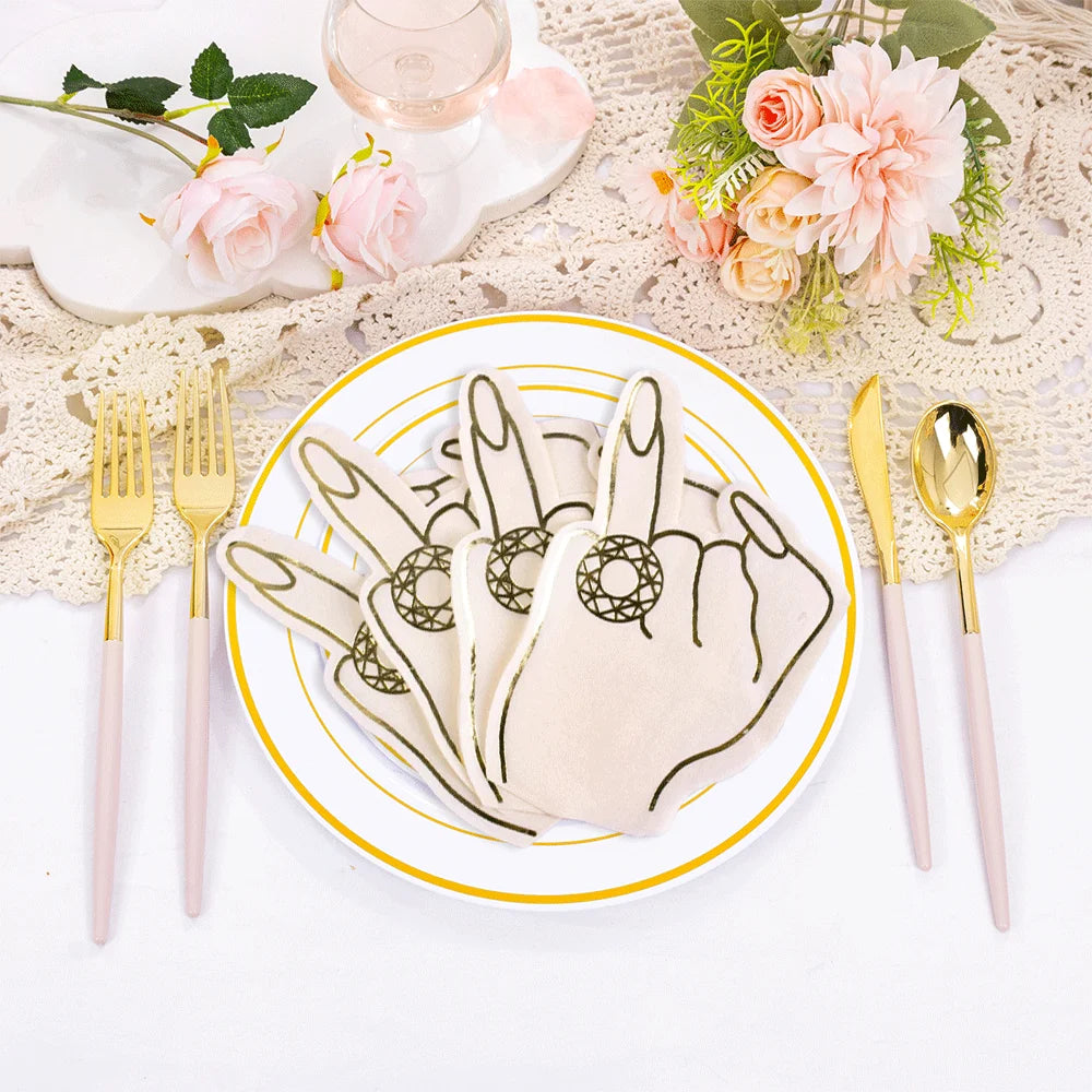 Decorative plate with ring finger hen party napkins on a table setting with gold cutlery and flowers.
