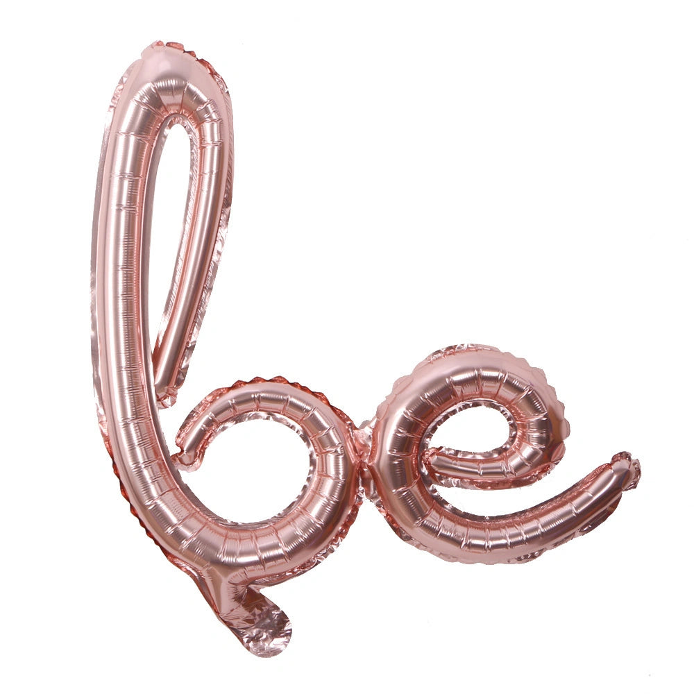 Rose gold 'be' balloon on a white background
