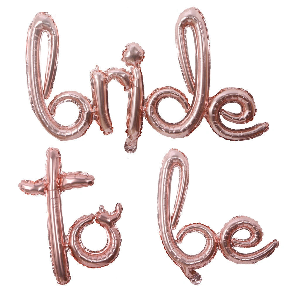 Rose gold foil balloon letters spelling 'bride to be' on a plain white background.