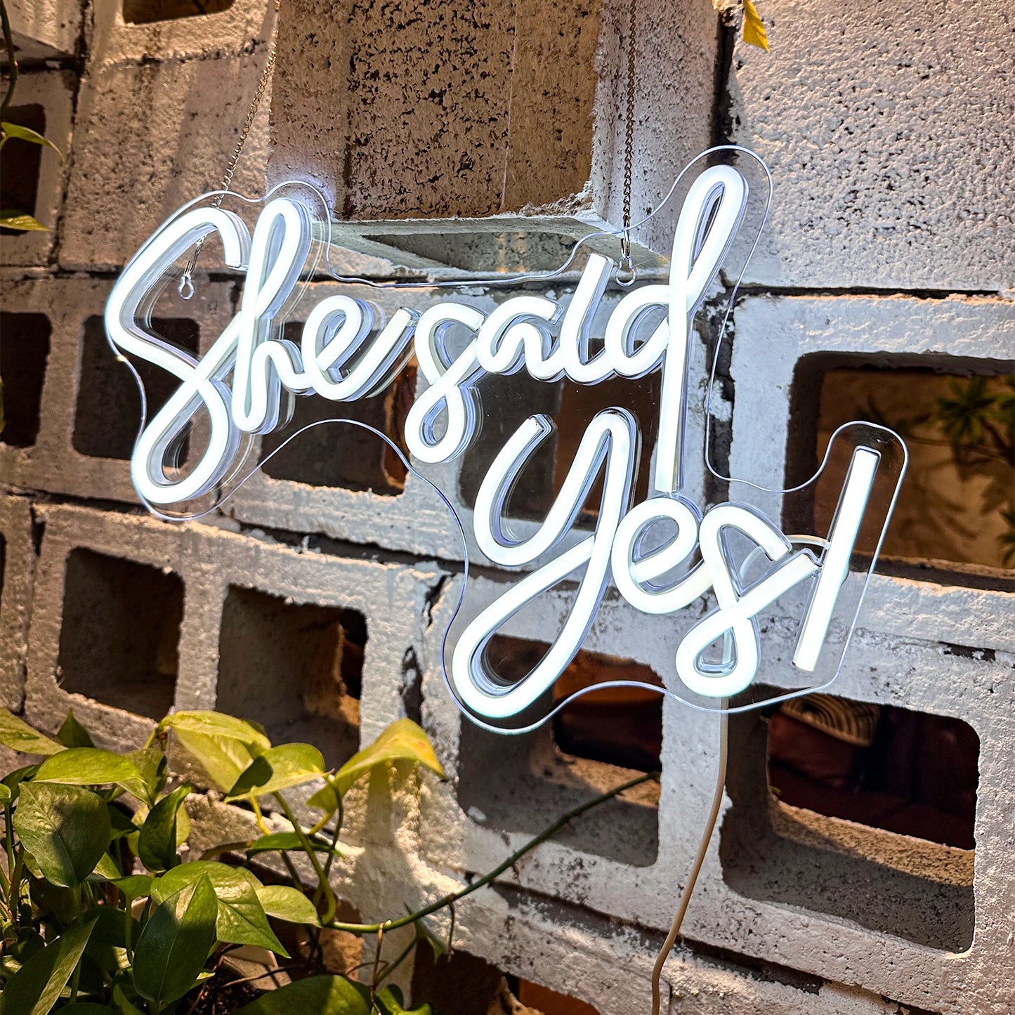 Neon sign with 'She said yes!' text on a concrete wall.