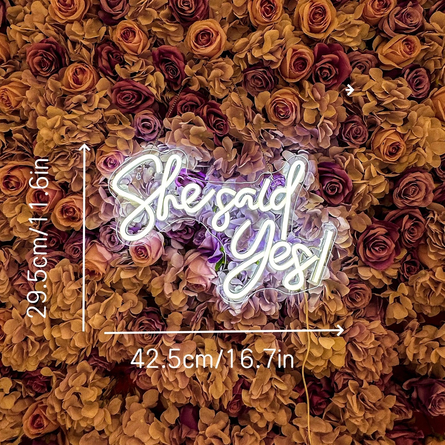 Neon sign with 'She said Yes!' surrounded by colorful flowers with measurements.
