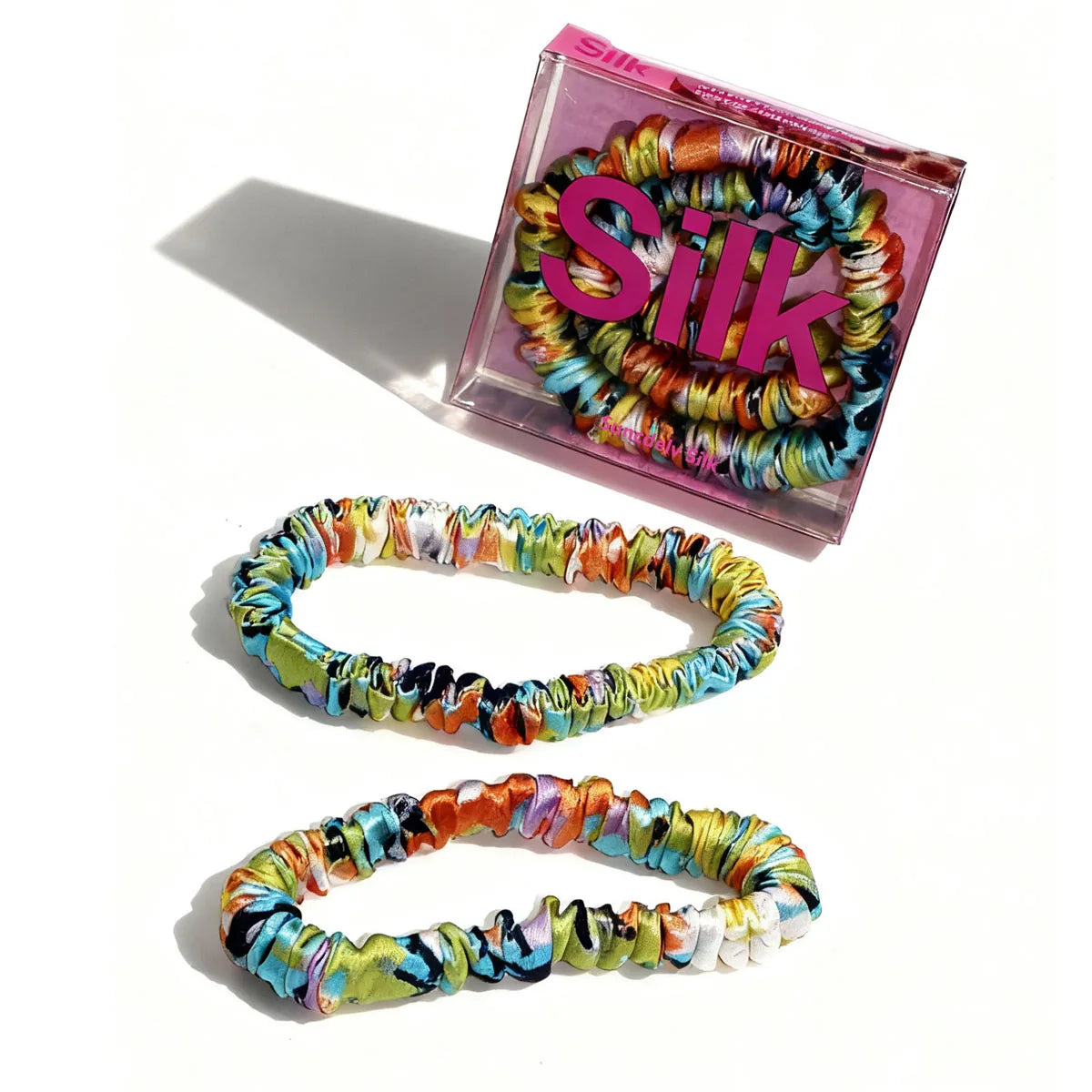 Colorful hair ties with 'Silk' packaging on a white background