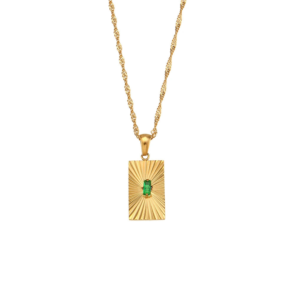 Gold pendant with a green gemstone on a white background
