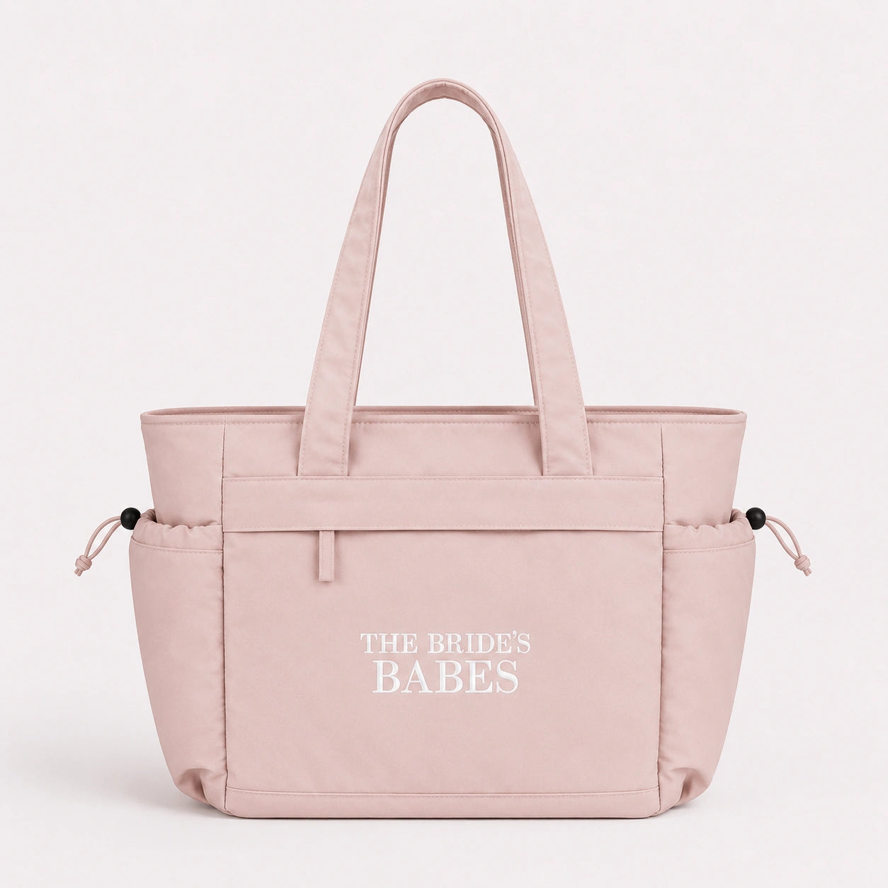 Pink tote bag with 'The Brides Babes' text on a white background