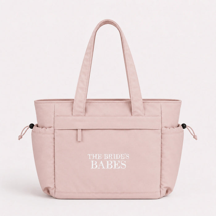 Pink tote bag with 'The Brides Babes' text on a white background