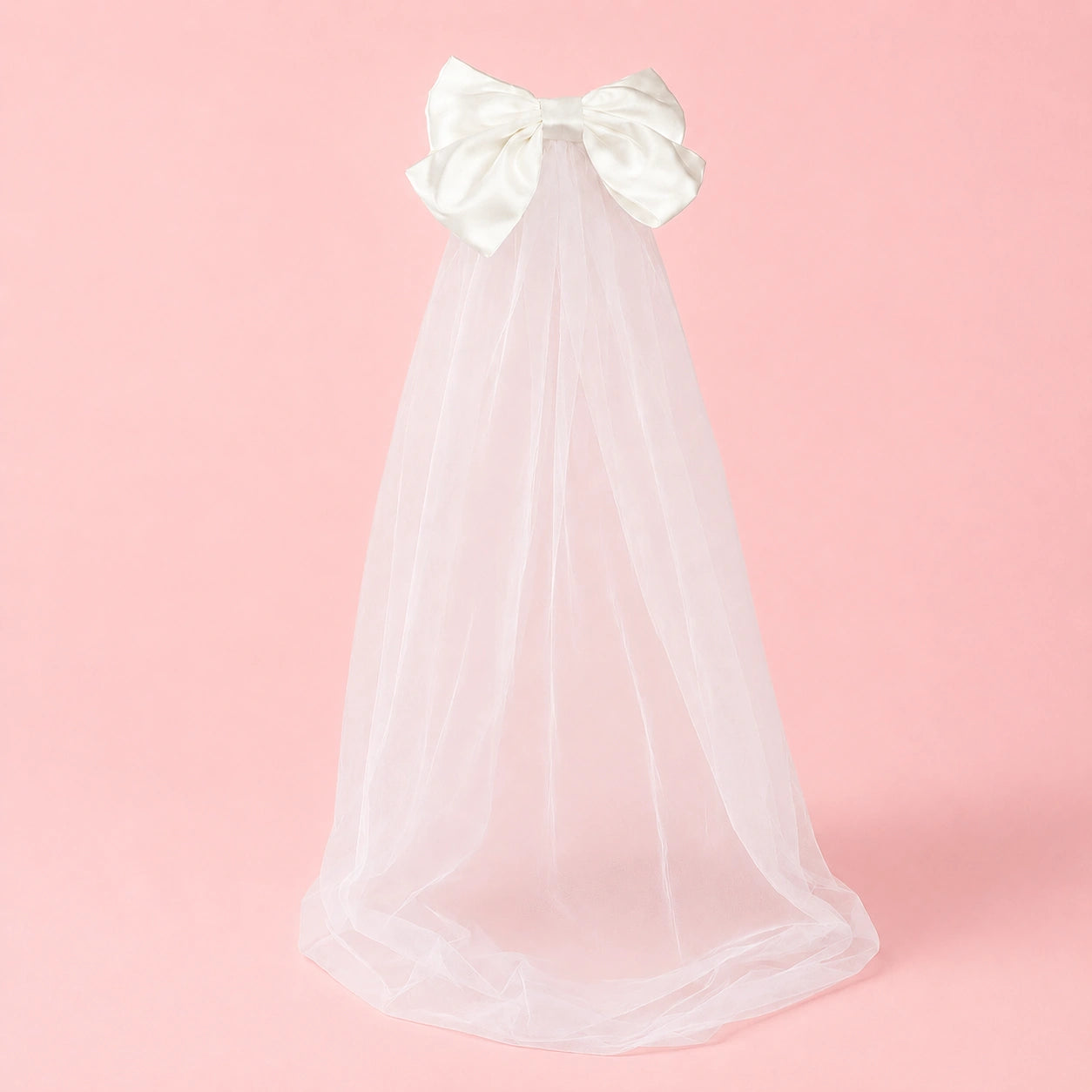 White veil with a large bow on a pink background