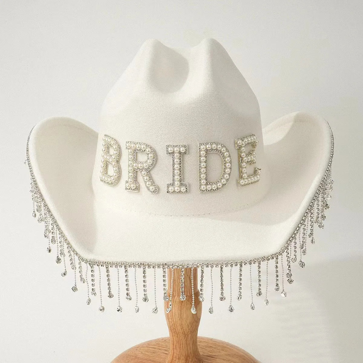 White cowboy hat with 'BRIDE' in rhinestones on a white background