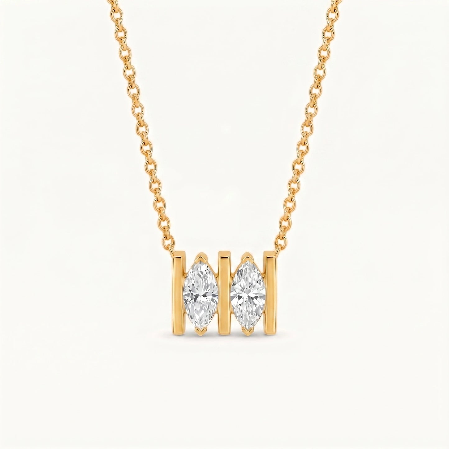 A yellow gold necklace with a pendant featuring two marquise-cut clear gemstones in gold settings, shown against a plain white background.