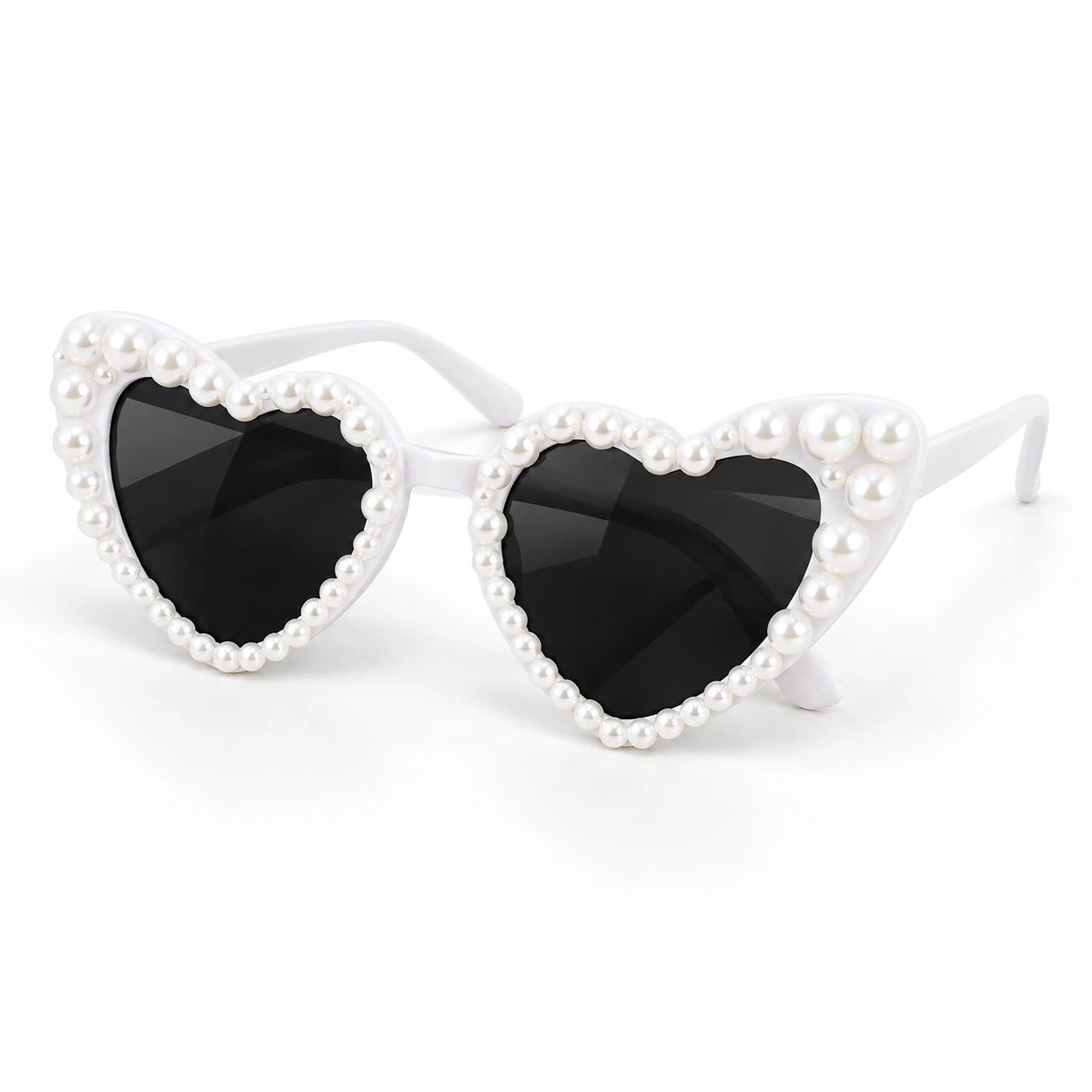 Heart-shaped sunglasses with black lenses and white frames adorned with small white faux pearls, shown on a clean white background.