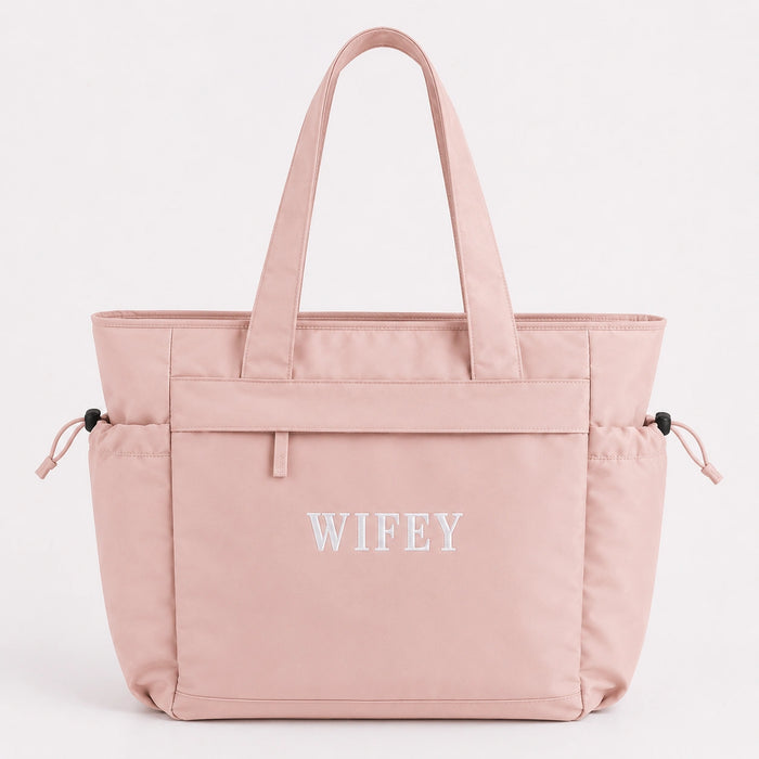Pink tote bag with 'WIFEY' text on a light gray background