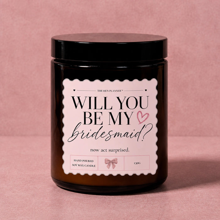 Candle with 'Will You Be My Bridesmaid?' label on a pink background