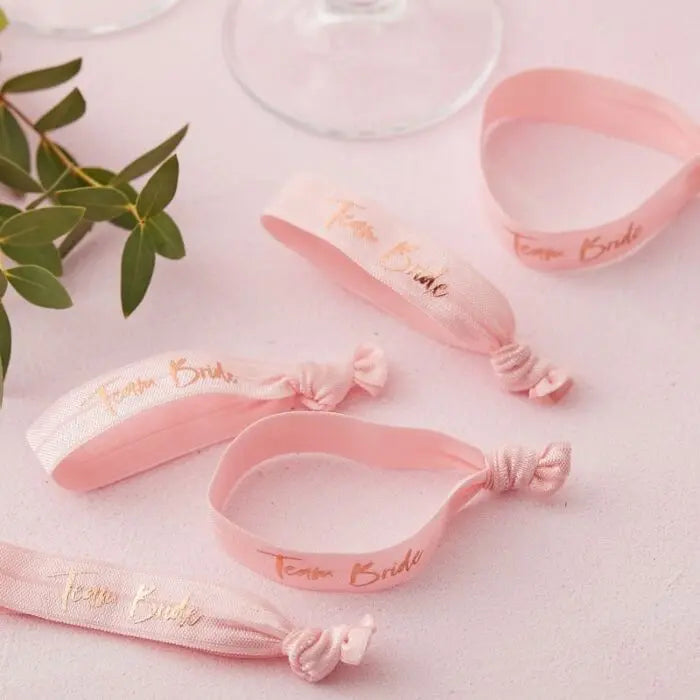 Pink 'Team Bride' satin wristbands for hen party favors, bachelorette accessories with gold text